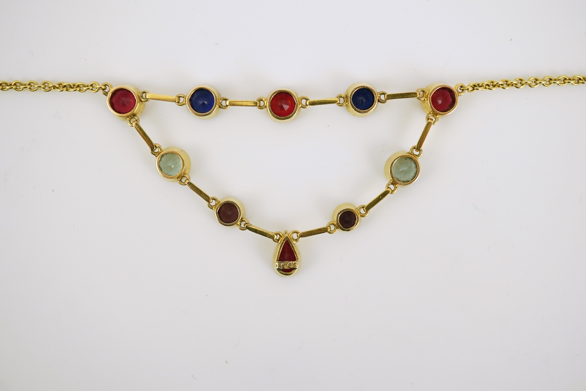 An early 20th century 15ct gold and ten stone multi coloured doublet set necklace